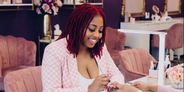 Smiling woman getting a manicure in a chic salon.