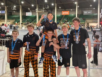 Group of young wrestlers celebrating with medals.