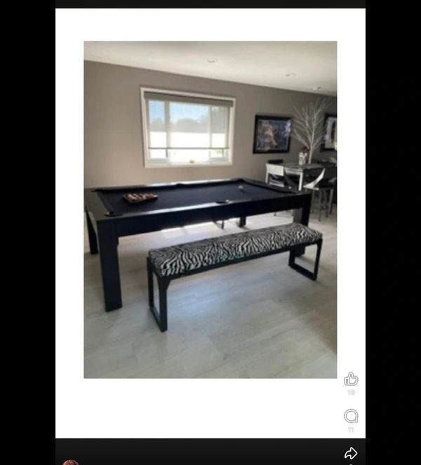 Modern black pool table with zebra-patterned bench in a stylish room.