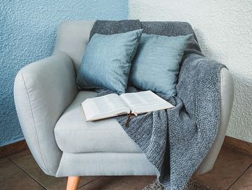 Armchair with cushions and draped blanket