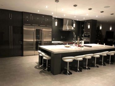 Modern black gloss kitchen with large island and bar stools