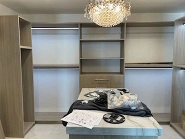 Walk-in closet with gray wood-grain shelving and center island