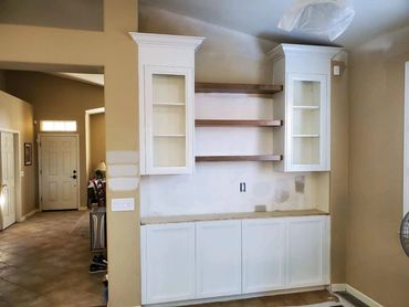 White built-in hutch with glass cabinets and floating shelves
