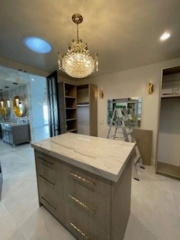 Closet island with drawers under crystal chandelier