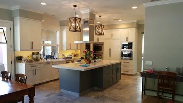 White kitchen with gray island and pendant lights