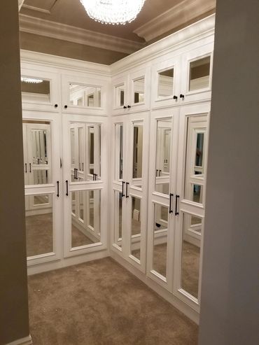 White closet with mirrored cabinet doors