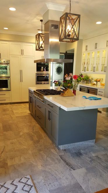 White kitchen with gray island and lantern pendants