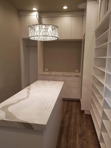 White walk-in closet with marble-top island