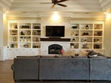 White built-in bookshelves around fireplace and TV