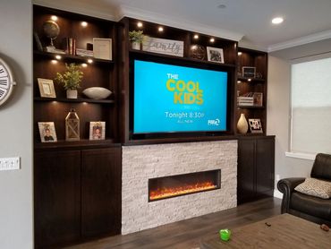 Dark wood entertainment center with stone fireplace