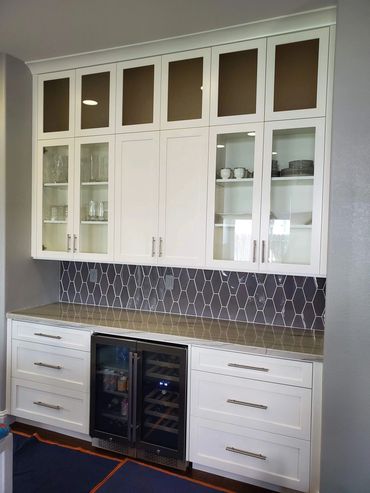 White built-in bar with glass uppers and wine fridge