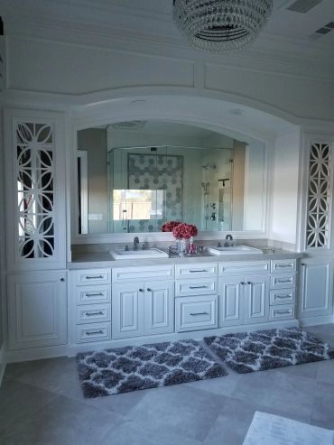 White double vanity with arched mirror and glass cabinets