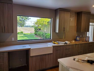 Wood-grain kitchen with farmhouse sink and picture window