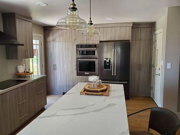 Wood-grain kitchen with marble island and pendants