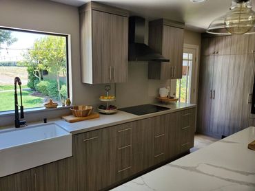Wood-grain kitchen with farmhouse sink and marble counters