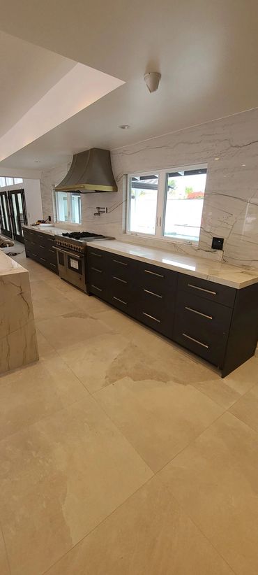 Long dark kitchen cabinet run with range hood