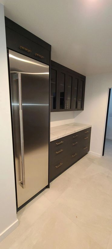 Dark kitchen cabinets beside stainless refrigerator