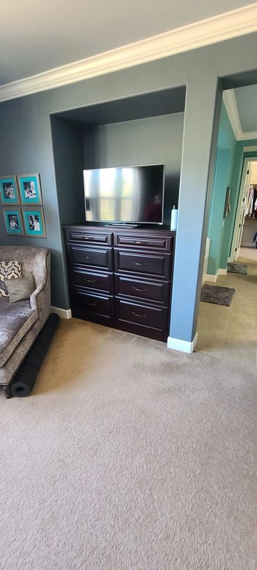 Dark wood dresser with TV in bedroom