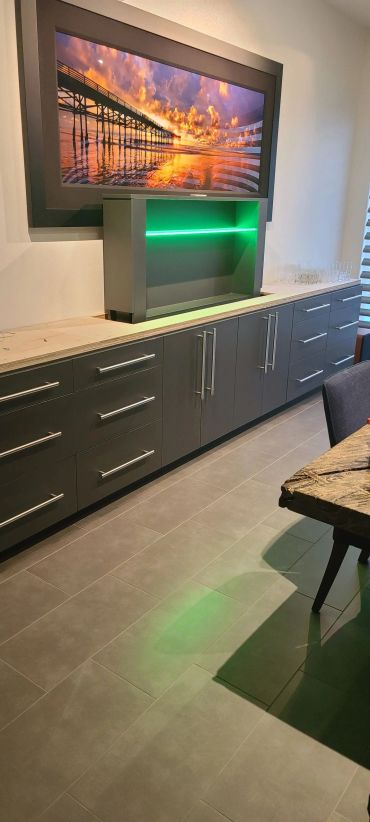 Dark media cabinet with green-lit TV lift