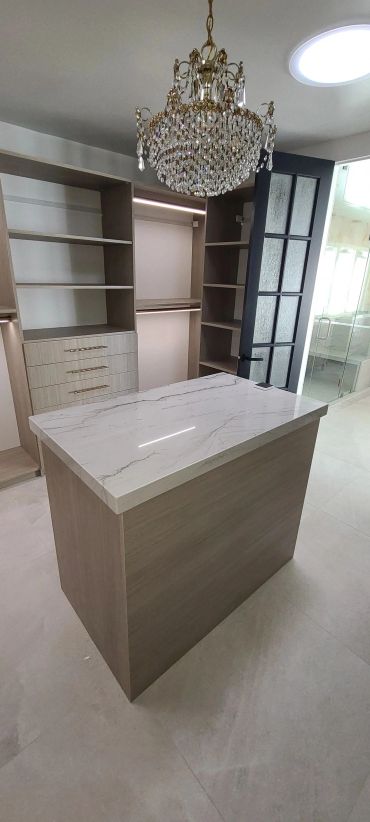 Wood-grain closet island under chandelier