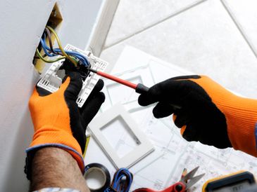 Electrician working safely on switches and sockets of a residential electrical system