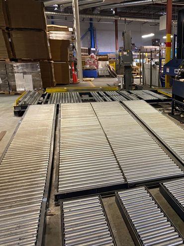 Metal roller conveyors in an industrial warehouse setting.