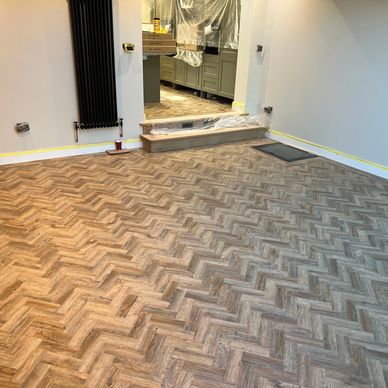 Newly installed herringbone lvt flooring in a room under renovation.