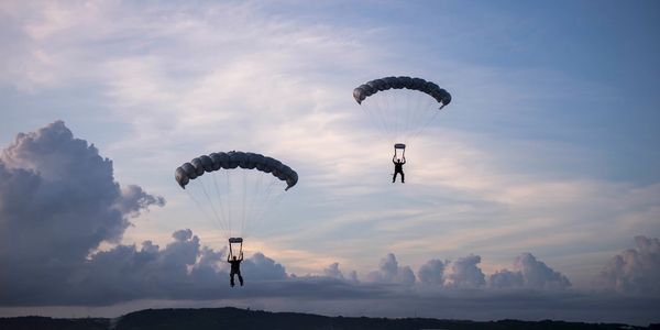 two military freefall parachutists under canopy