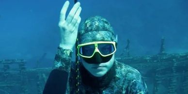 freediver in camouflaged wetsuit