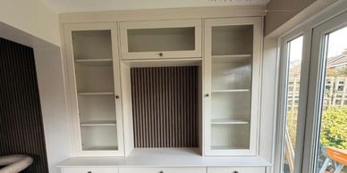 White wooden cabinet with glass doors and drawers below.