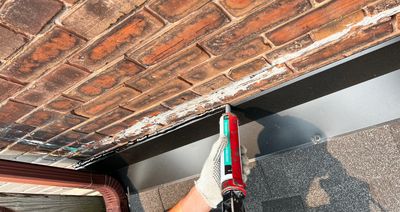 applying a bead of caulking or sealant along the top edge of the flashing where it meets the brick