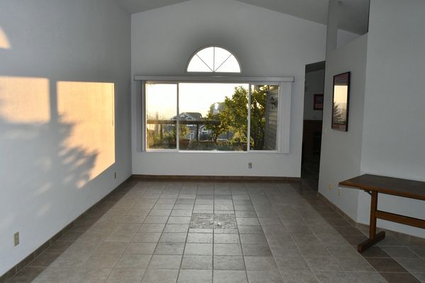 Living room with vaulted ceilings and ample natural light with views from the back yard.
