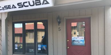 Exterior of a scuba diving shop with a red door.