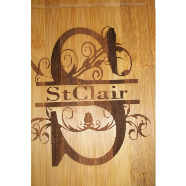 Wooden board engraved with the name 'StClair' and decorative floral design.