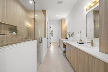 Modern bathroom with wood accents and glass shower enclosure.