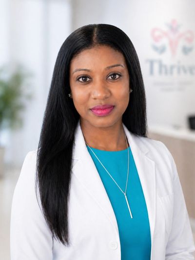 Professional woman in a white coat smiling confidently.