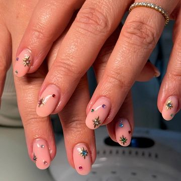 Nude nails with star and gem decorations.