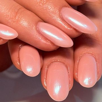 Shiny nude pink manicured nails on hands.