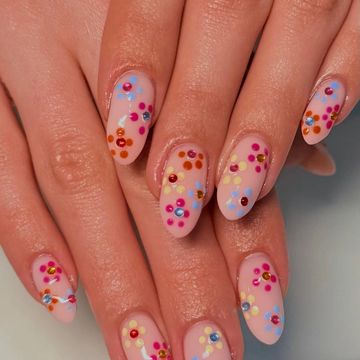 Nails with pastel and multicolored dot designs.
