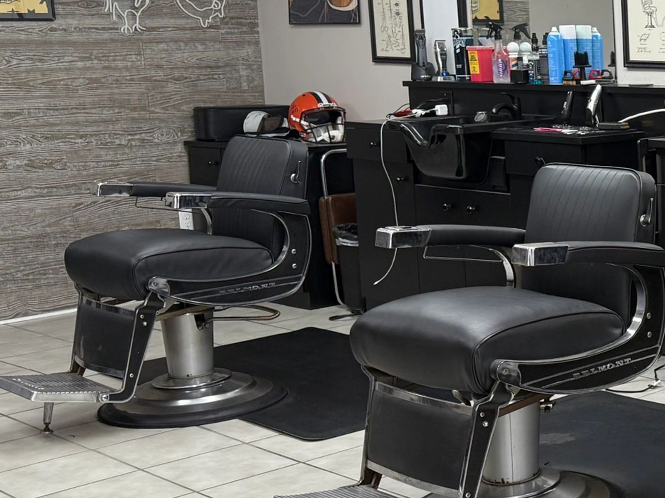 A stylish barbershop with vintage chairs and decorative wall art.