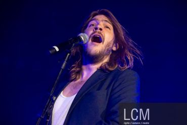 Male singer passionately performing on stage.
