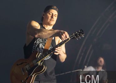 Musician tuning guitar during live performance.