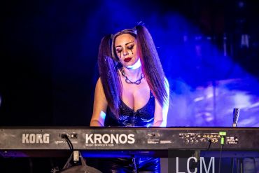 Woman playing a keyboard with blue lighting.