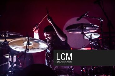 Drummer passionately playing in a live concert.