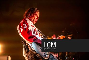 Guitarist passionately playing live on stage.