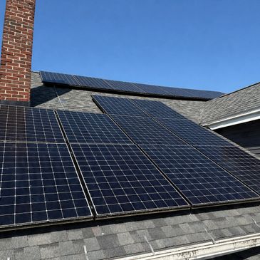 Solar panels installed on a residential roof under clear blue sky.
