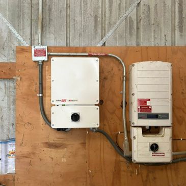 Electrical control panels mounted on a wooden board inside an industrial setting.