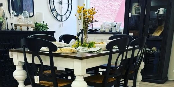 Cozy dining table set with black chairs and decorative centerpiece.