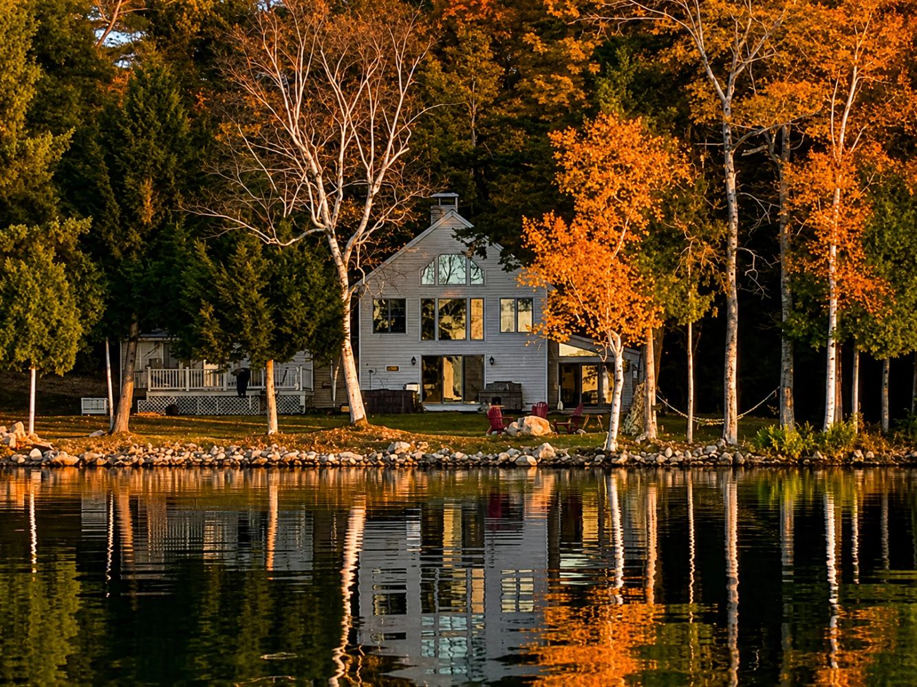 White lake house reflected in autumn water
