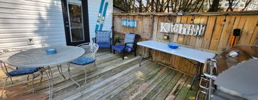 Cozy wooden backyard deck with seating and grill for outdoor gatherings.
